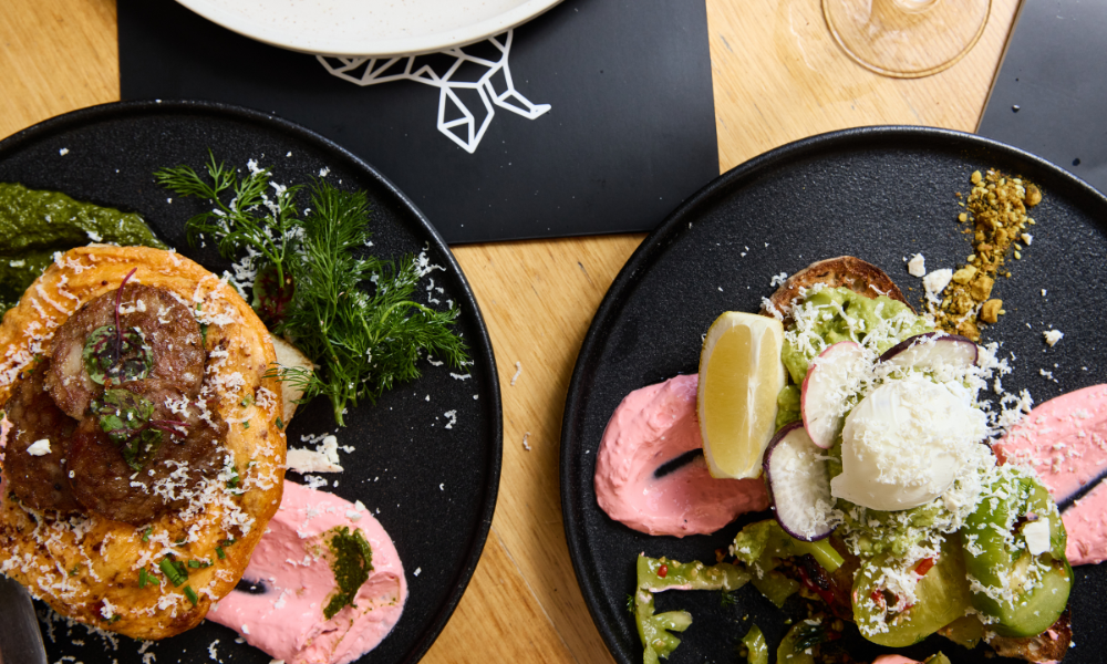 Colourful breakfast dishes at The Winey Cow Mornington – gourmet smashed avo on sourdough with poached egg and lemon, and savoury brunch with sausage and greens
